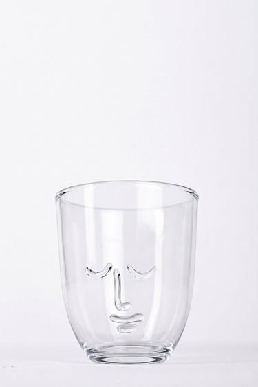 Clear glass with face design on a white background