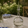 Clear glass decanter on a table with floral background