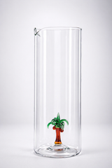 Clear glass vase with a small palm tree decoration on a white background
