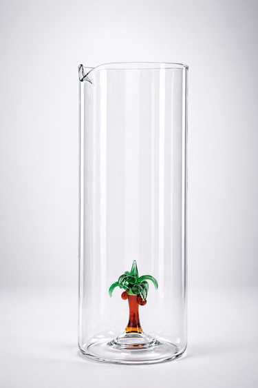 Clear glass vase with a small palm tree decoration on a white background