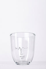 Clear glass with face design on a white background