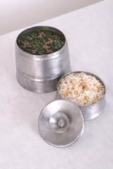 Two metal containers with food on a white surface
