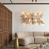 Modern living room with a beige sofa, decorative wall light fixture, and wooden side table.